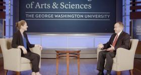 Tara Sinclair and Dean Wahlbeck sitting and talking on a stage with a CCAS logo behind